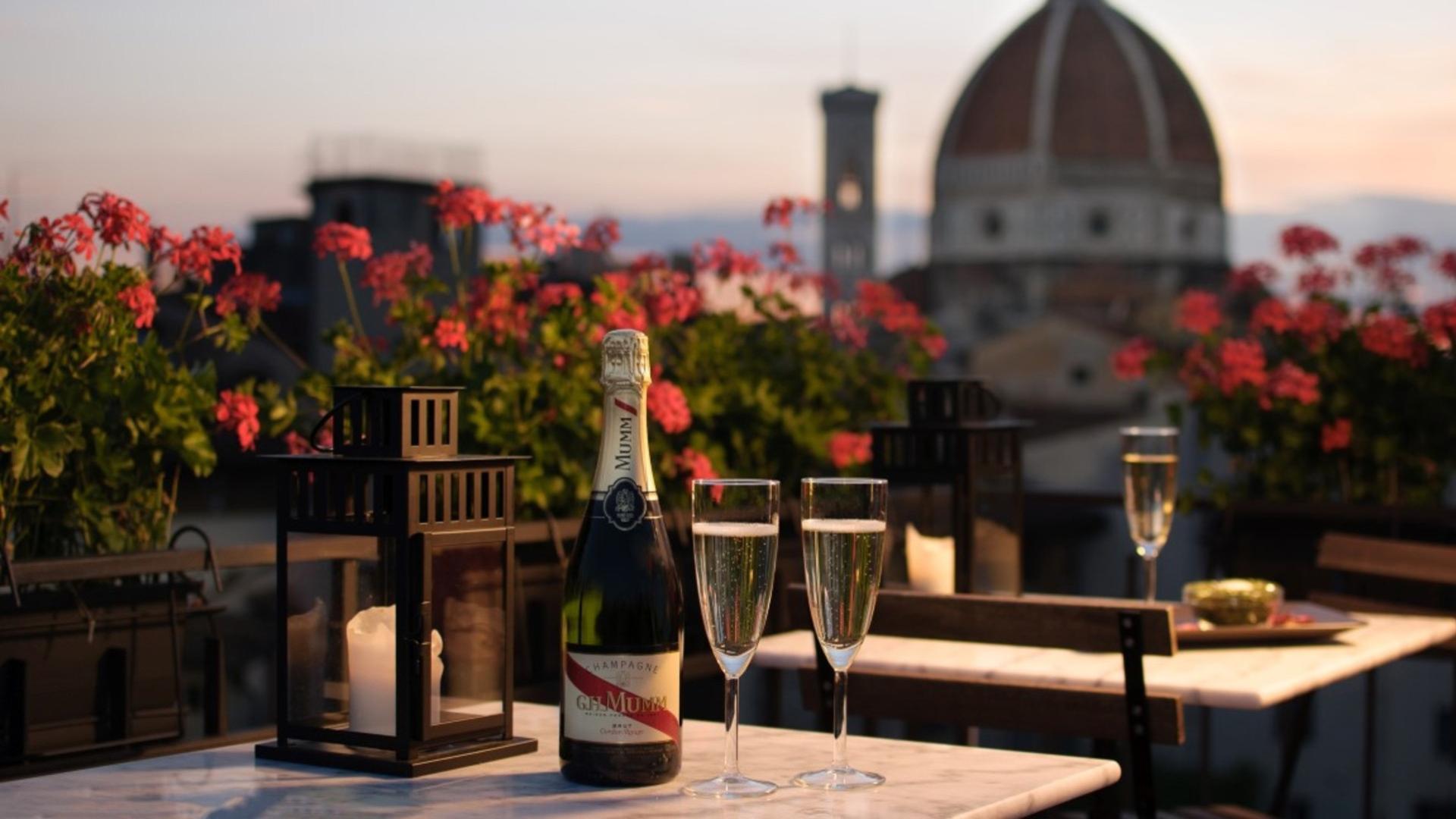 Champagne e bicchieri su un tavolo con vista sulla cupola di Firenze.